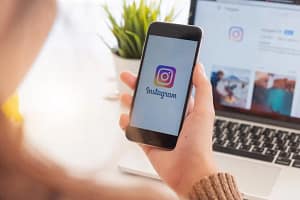 woman holding phone and signing into Instagram