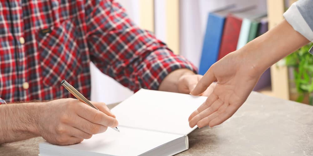Author signing book at event