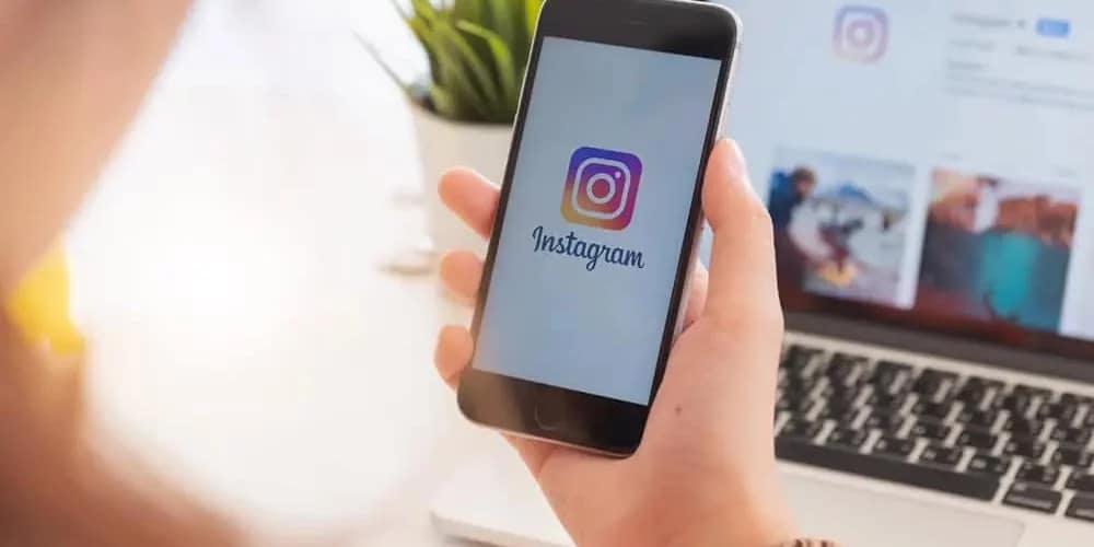 woman holding phone and signing into Instagram