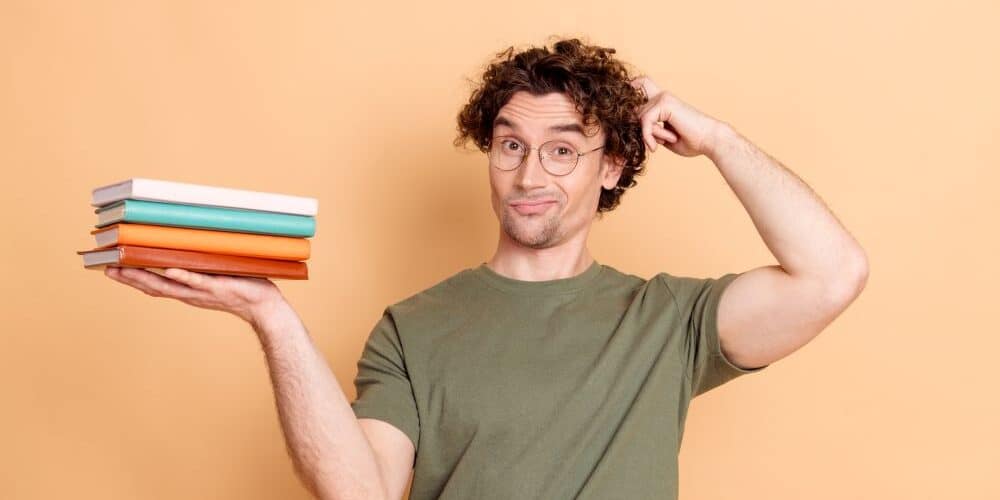 man holding books in hand questiong plot vs character